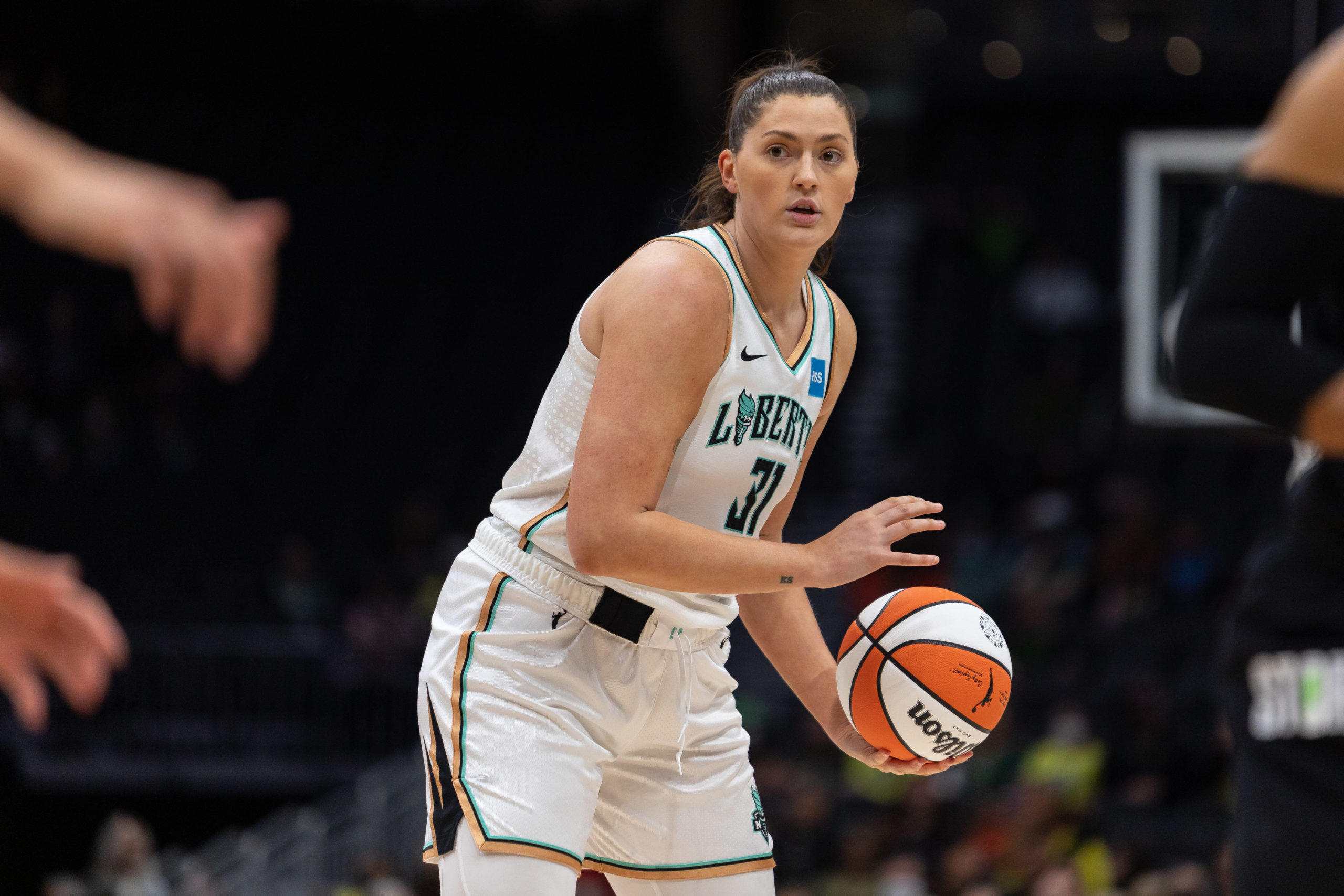 New York Liberty center Stefanie Dolson faces sideways and holds the ball at her hip while looking downcourt