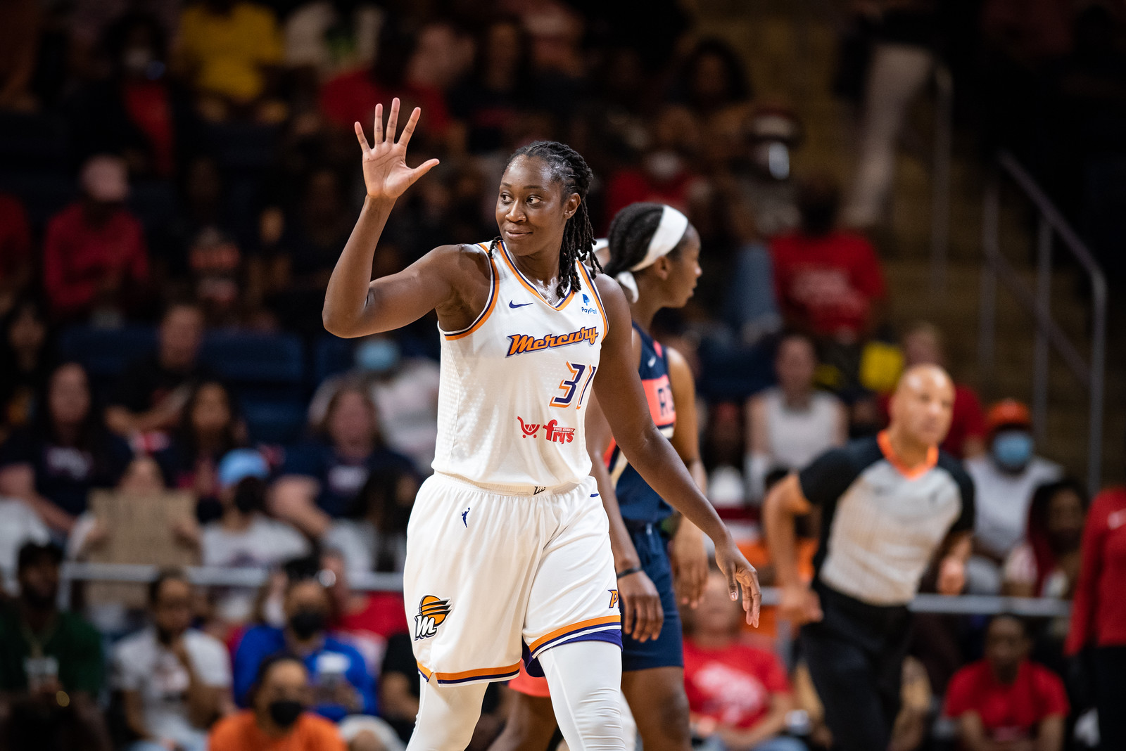 Phoenix Mercury center Tina Charles looks towards the sideline while smiling and waving