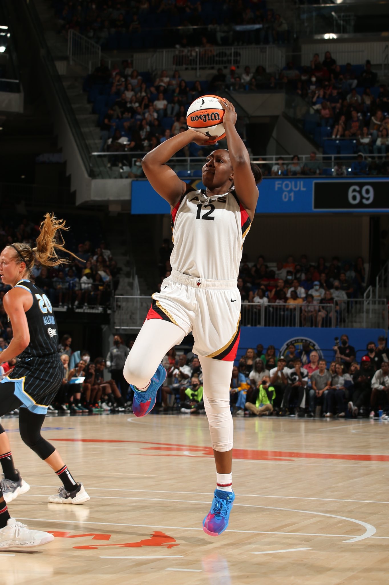 Las Vegas Aces point guard Chelsea Gray jumps off of one leg with the ball raised above her head for a midrange jumper during the Commissioner's Cup