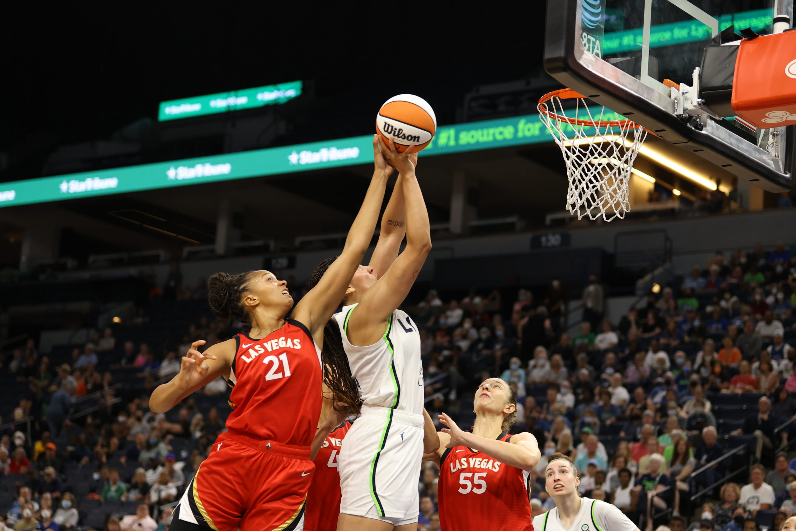 Las Vegas Aces center Iliana Rupert (21) tries to block Minnesota Lynx forward Natalie Achonwa's close-range shot from behind.