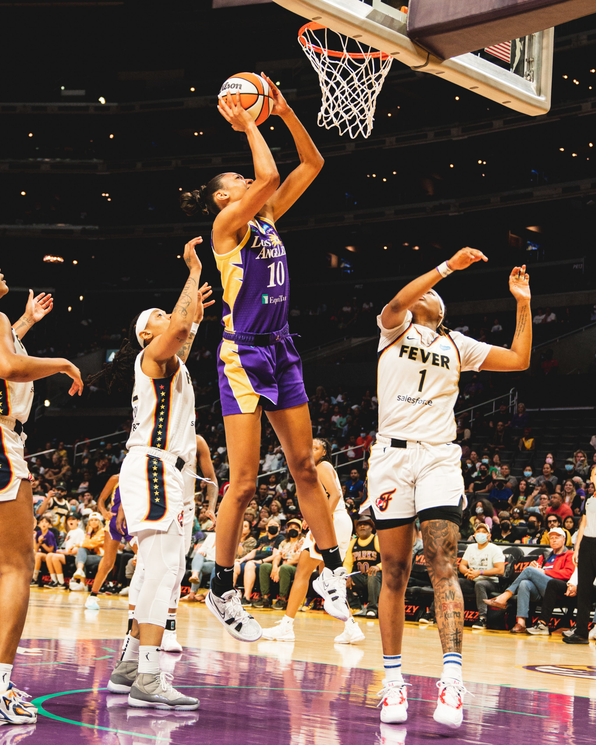 Olivia Nelson-Ododa jumps from under the rim with the ball over her head to go up for a layup