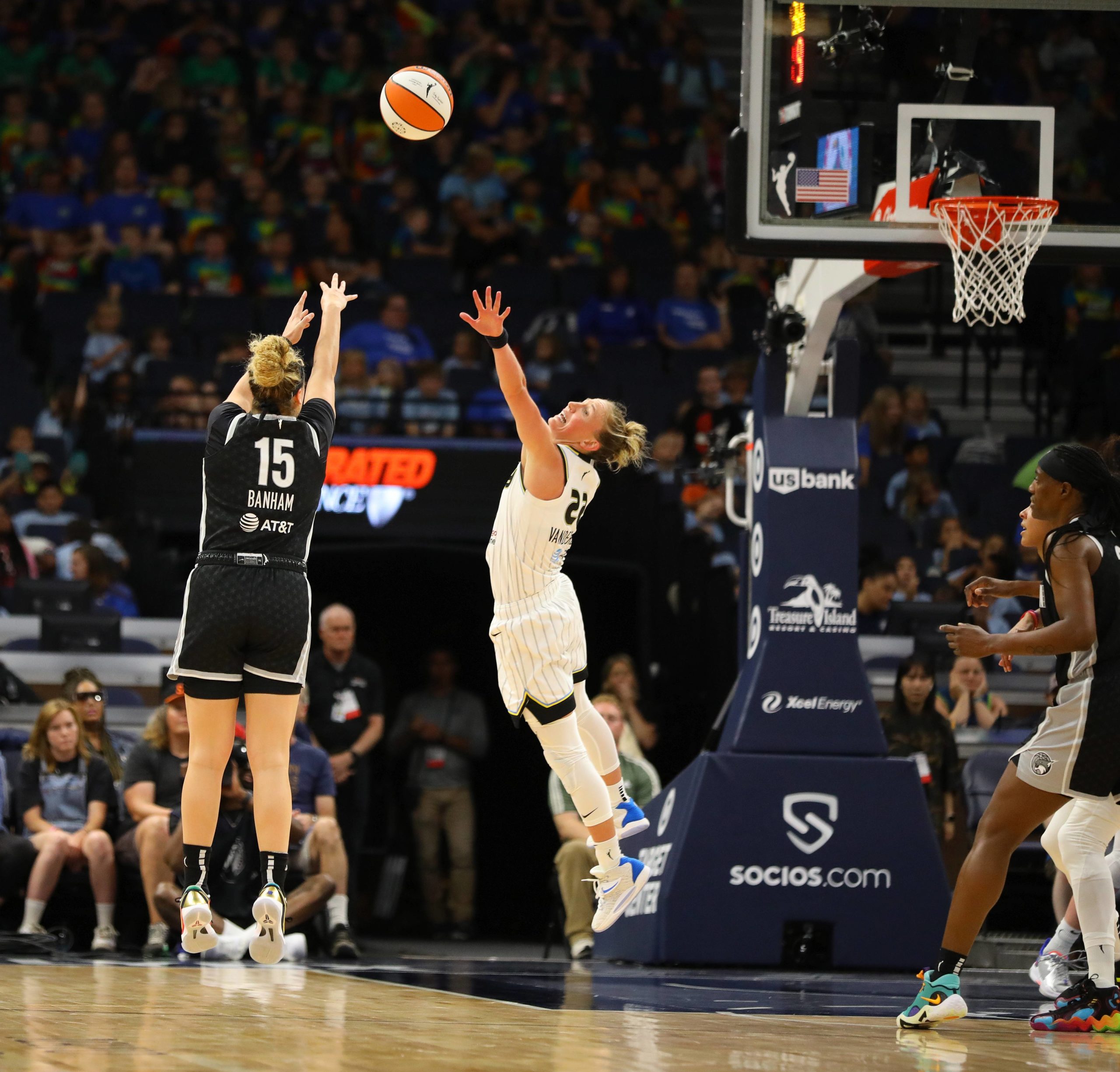 Minnesota combo guard Rachel Banham shoots over Chicago point guard Courtney Vandersloot who contests the shot. Lynx center Sylvia Fowles boxes out near by the basket.