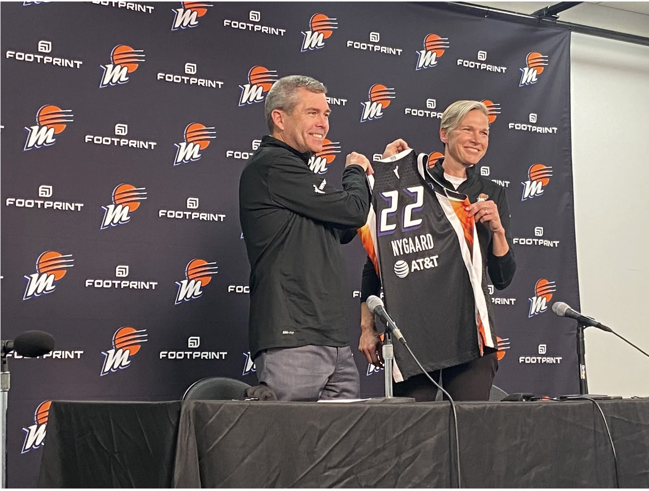 New Phoenix Mercury head coach Vanessa Nygaard holds up a Mercury jersey with general manager Jim Pitman at her introductory press conference on Monday. (Photo credit: Alex Simon)