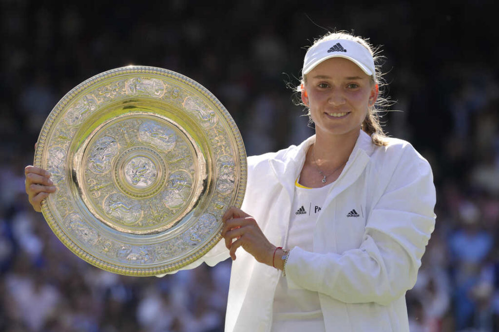 Kazakhstan's Elena Rybakina holds the trophy as she celebrates after beating Tunisia's Ons Jabeur to win the final of the women's singles on day thirteen of the Wimbledon tennis championships in London, Saturday, July 9, 2022. (AP Photo/Kirsty Wigglesworth)