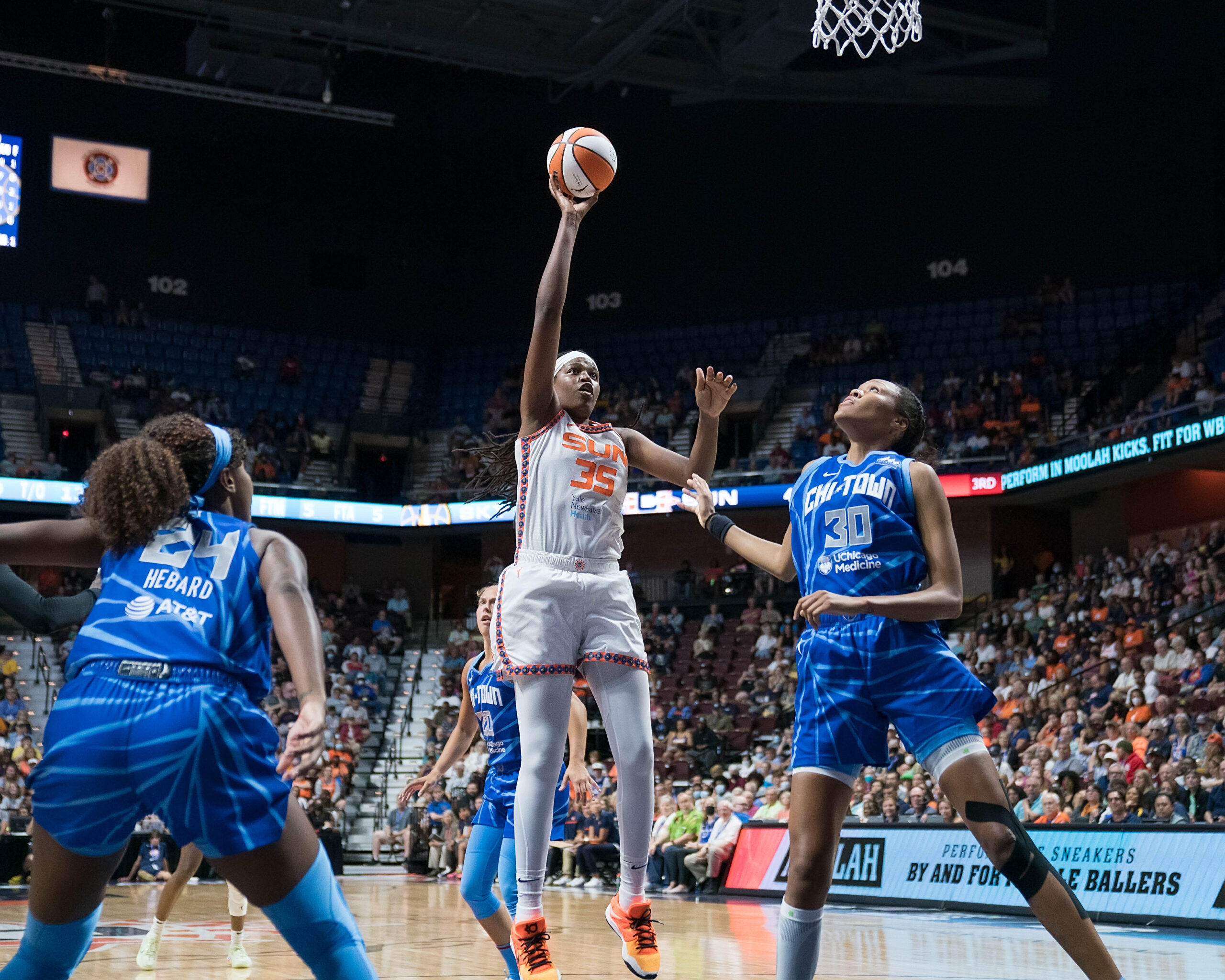 Sun center Jonquel Jones (35) goes for a layup over Sky big Azura Stevens (30). Sky forward Ruthy Hebard (24) boxes out nearby.