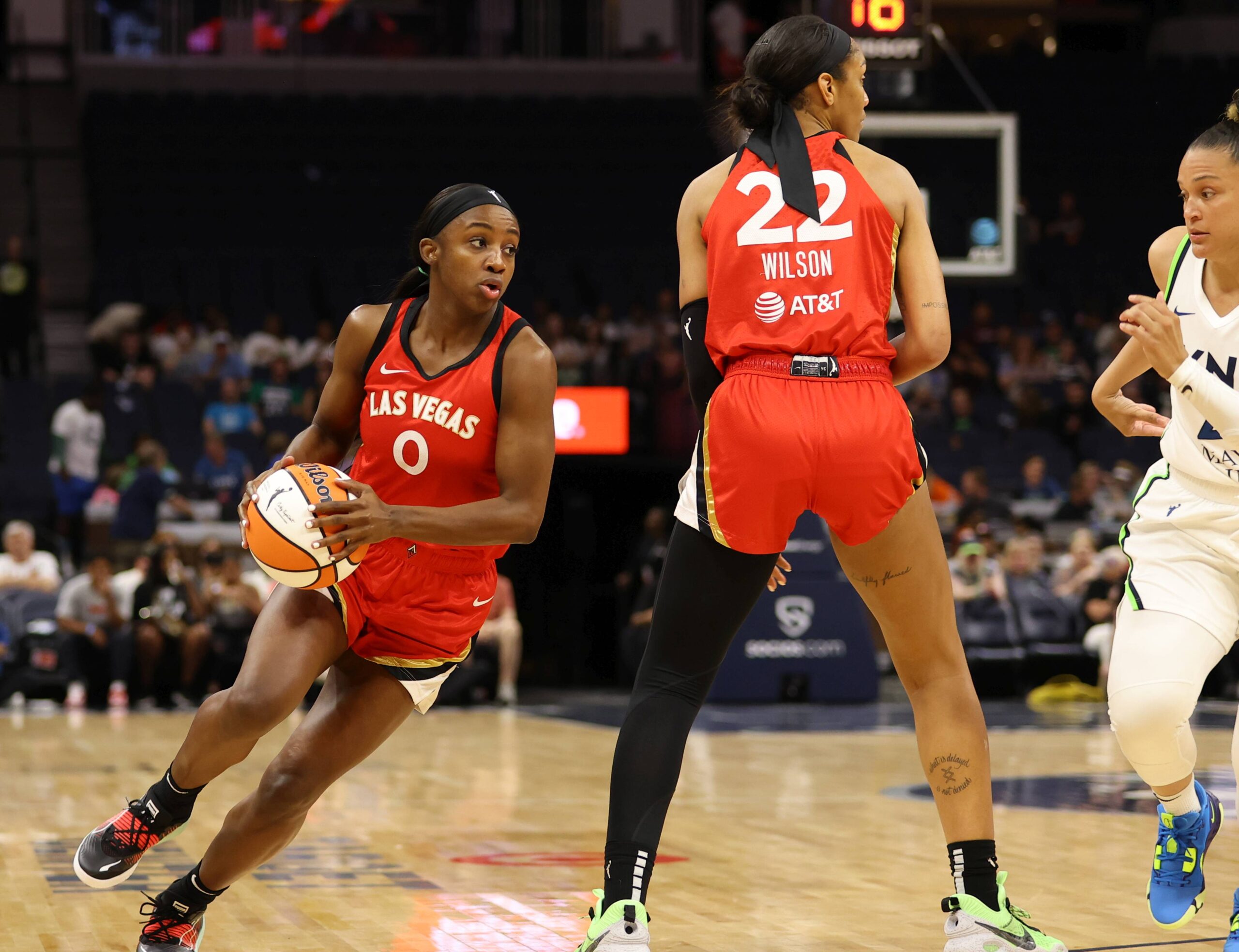 Aces wing Jackie Young (0) goes around a screen from Aces center A'ja Wilson (22). Lynx off-ball guard Kayla McBride (21) goes under the Wilson screen.