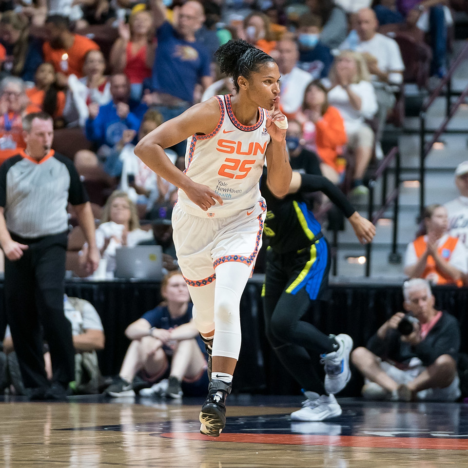 Connecticut Sun big Alyssa Thomas runs up the court while looking towards the fans and holding a finger to her mouth to shush them