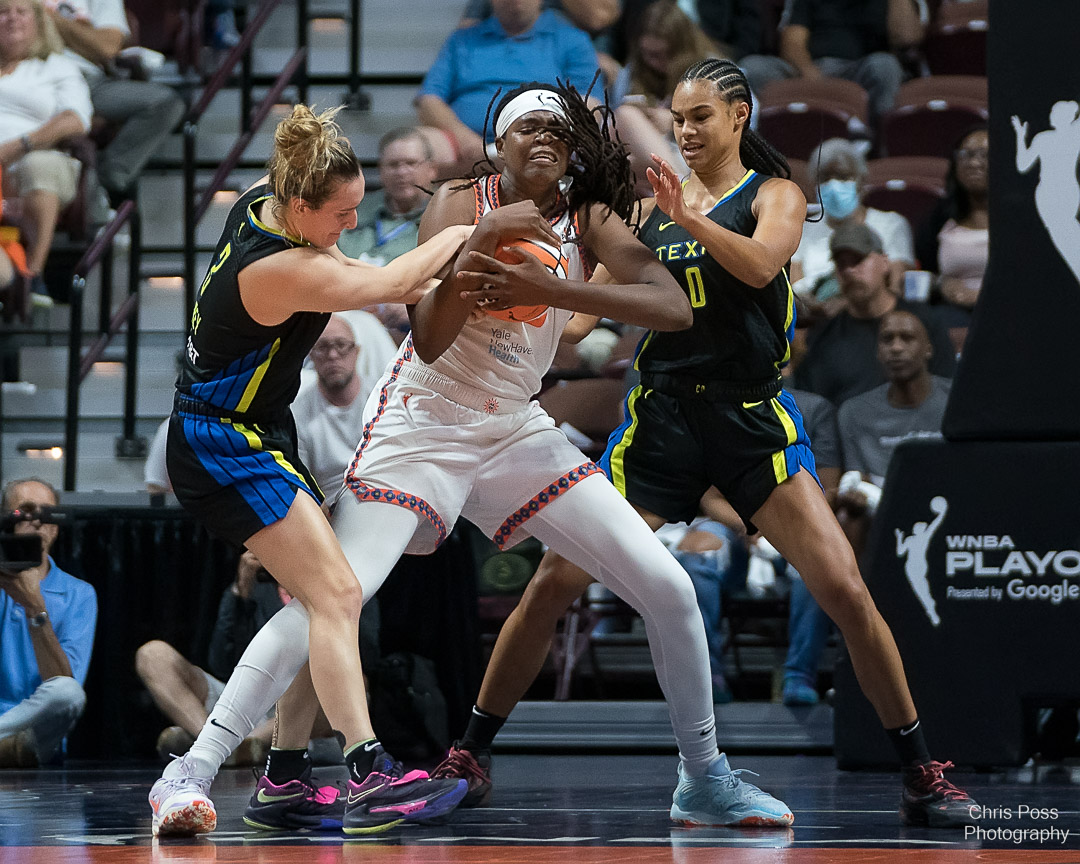 Dallas Wings wing Marina Mabrey (3) tries to wrestle the ball from Connecticut Sun big Jonquel Jones (35). Wings big Satou Sabally (0) defends Jones opposite Mabrey.