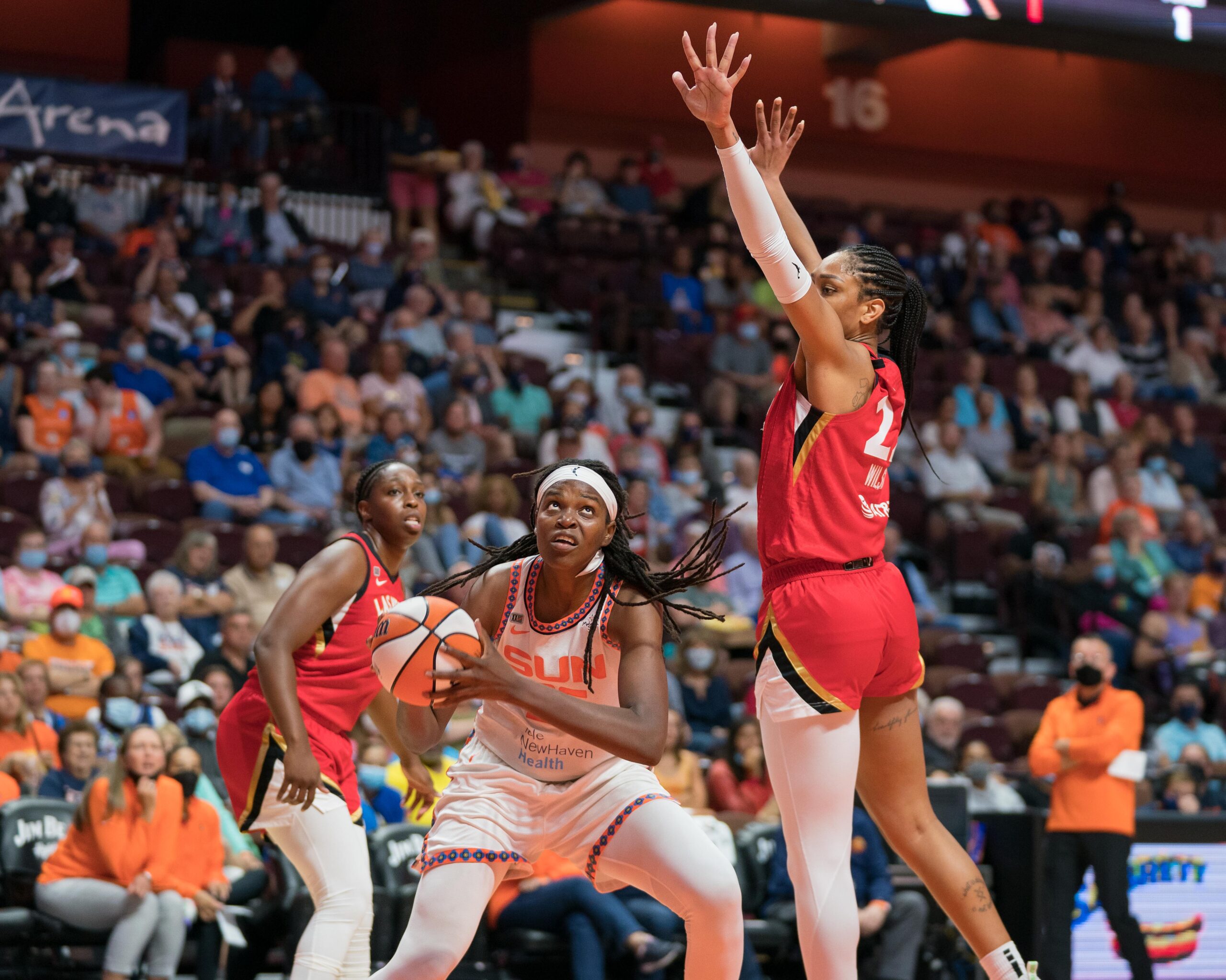 Sun center Jonquel Jones (35) looks to shoot while Aces center A'ja Wilson (22) contests. Aces point guard Chelsea Gray (12) stands behind Jones.