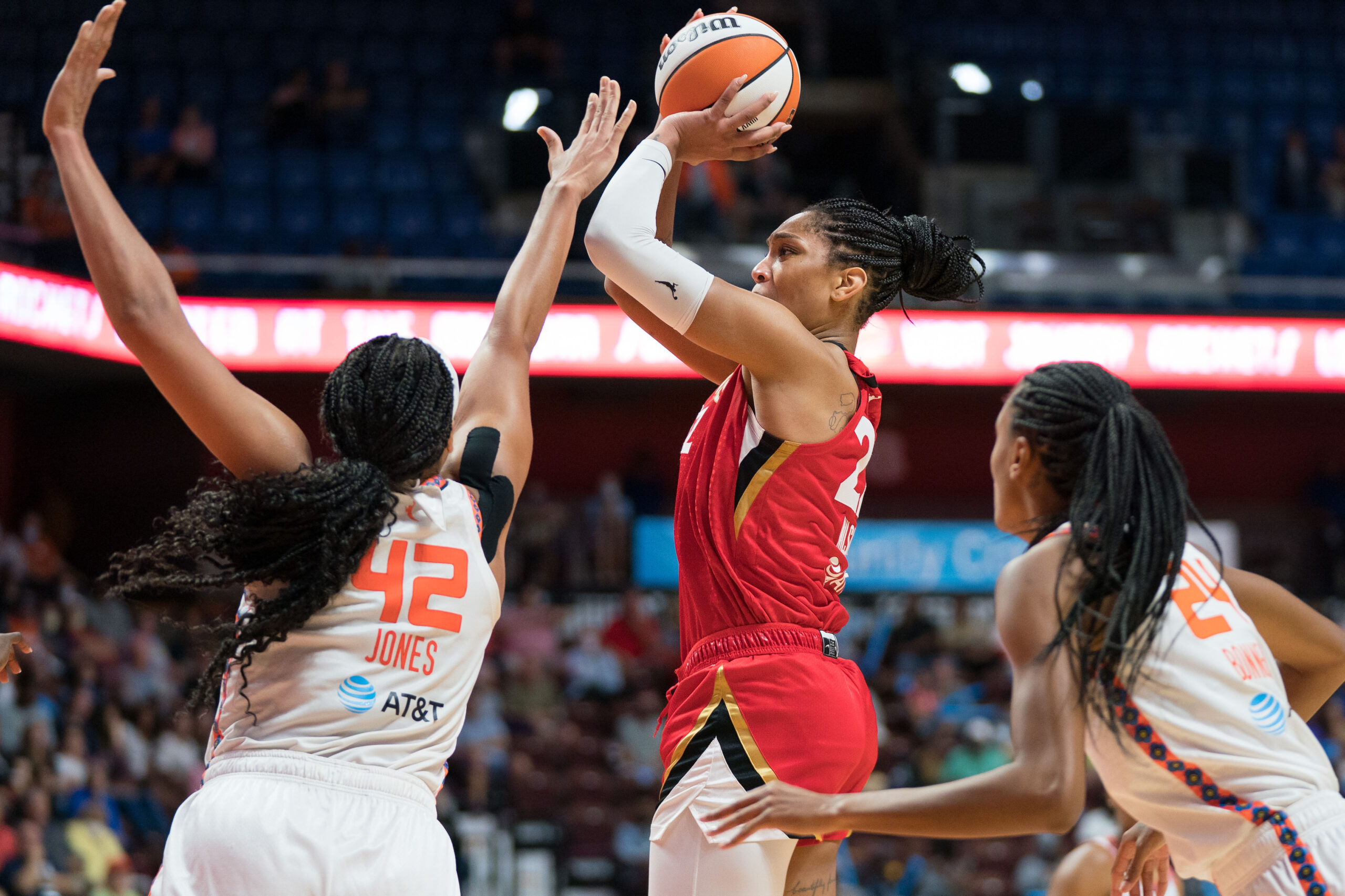 Las Vegas Aces center A'ja Wilson (22) shoots while Sun center Brionna Jones (42) contests the shot. Sun big wing DeWanna Bonner (24) closes out to the right.