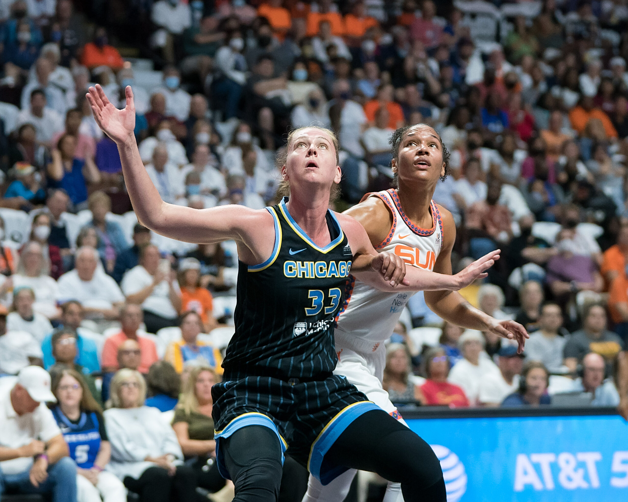 Chicago Sky big Emma Meesseman (33) boxes out Connecticut Sun big wing Alyssa Thomas (25). Meesseman's arms are outstretched, and both players are looking up toward the basket.