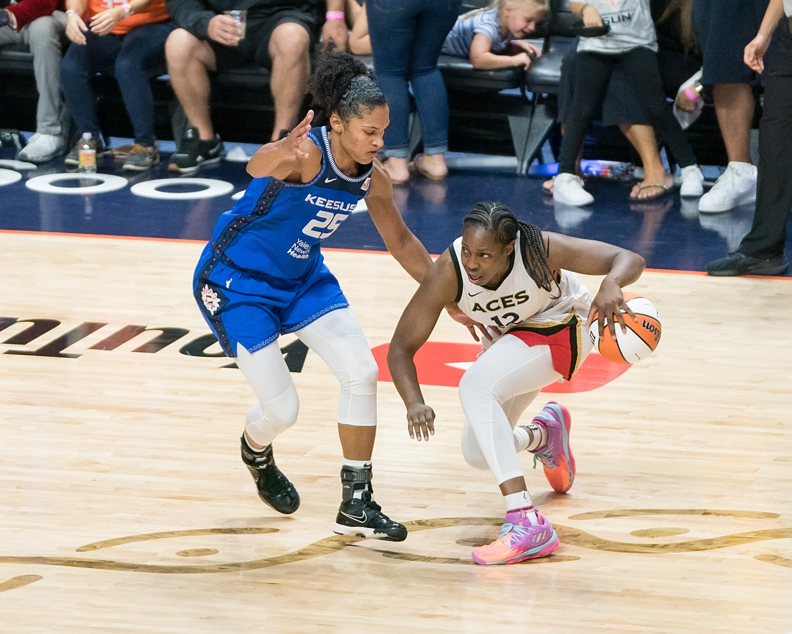 Las Vegas Aces guard Chelsea Gray keeps her dribble low with her left hand as Connecticut Sun forward Alyssa Thomas defends.