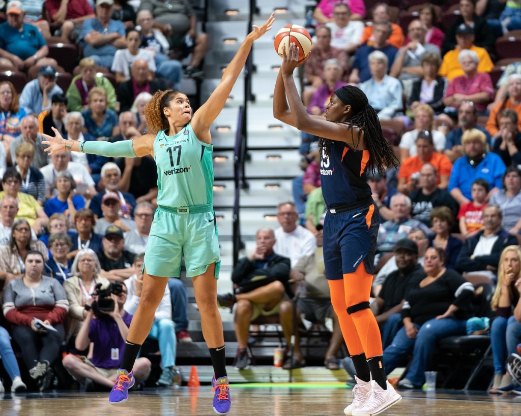 Connecticut Sun center Jonquel Jones shoots a jump shot as New York Liberty center Amanda Zahui B. contests.