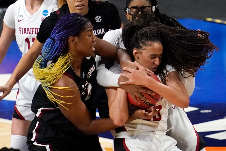 Stanford big wing Haley Jones holds onto the ball as South Carolina Gamecocks center Aliyah Boston tries to pry it away from besides Jones, while Cardinal big Fran Belibi tries to help Jones hold on from behind.