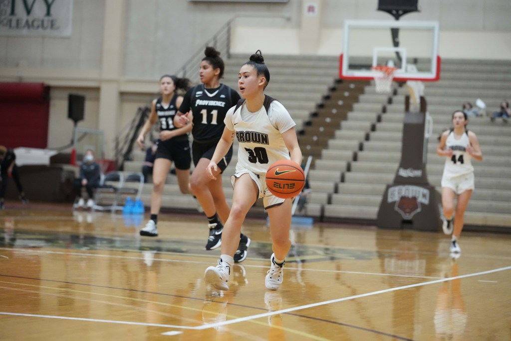 Brown's Bella Mauricio brings the ball over half court as a teammate and two Providence defenders trail the play.