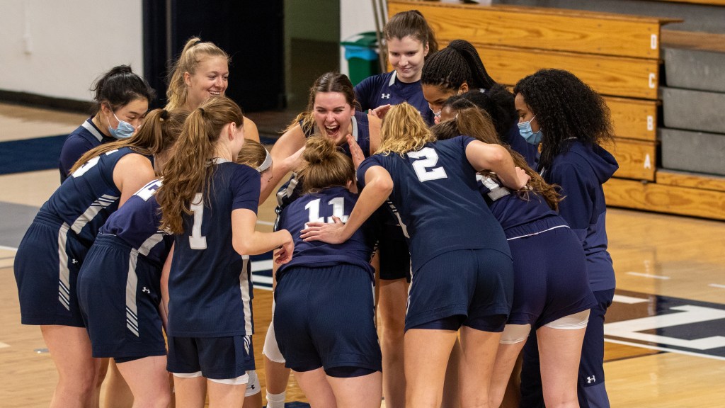 Wearing dark blue jerseys, Yale players huddle.