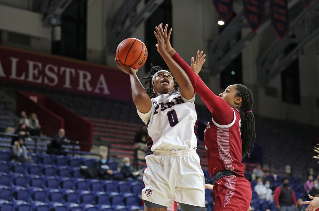 Penn forward Jordan Obi shoots despite defensive pressure.