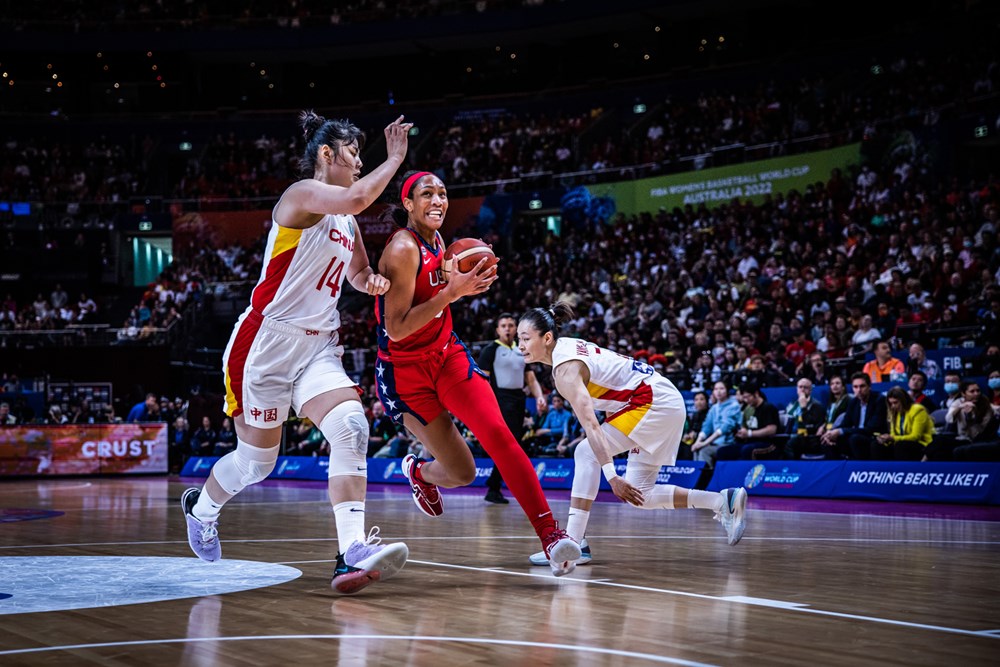 USA's A'ja Wilson (9) goes for a left-handed layup over China's Li Yueru (14), who defends. Another Chinese player steps toward Wilson to defend.