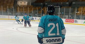 Sonnet player number 21 looks on during hockey action.