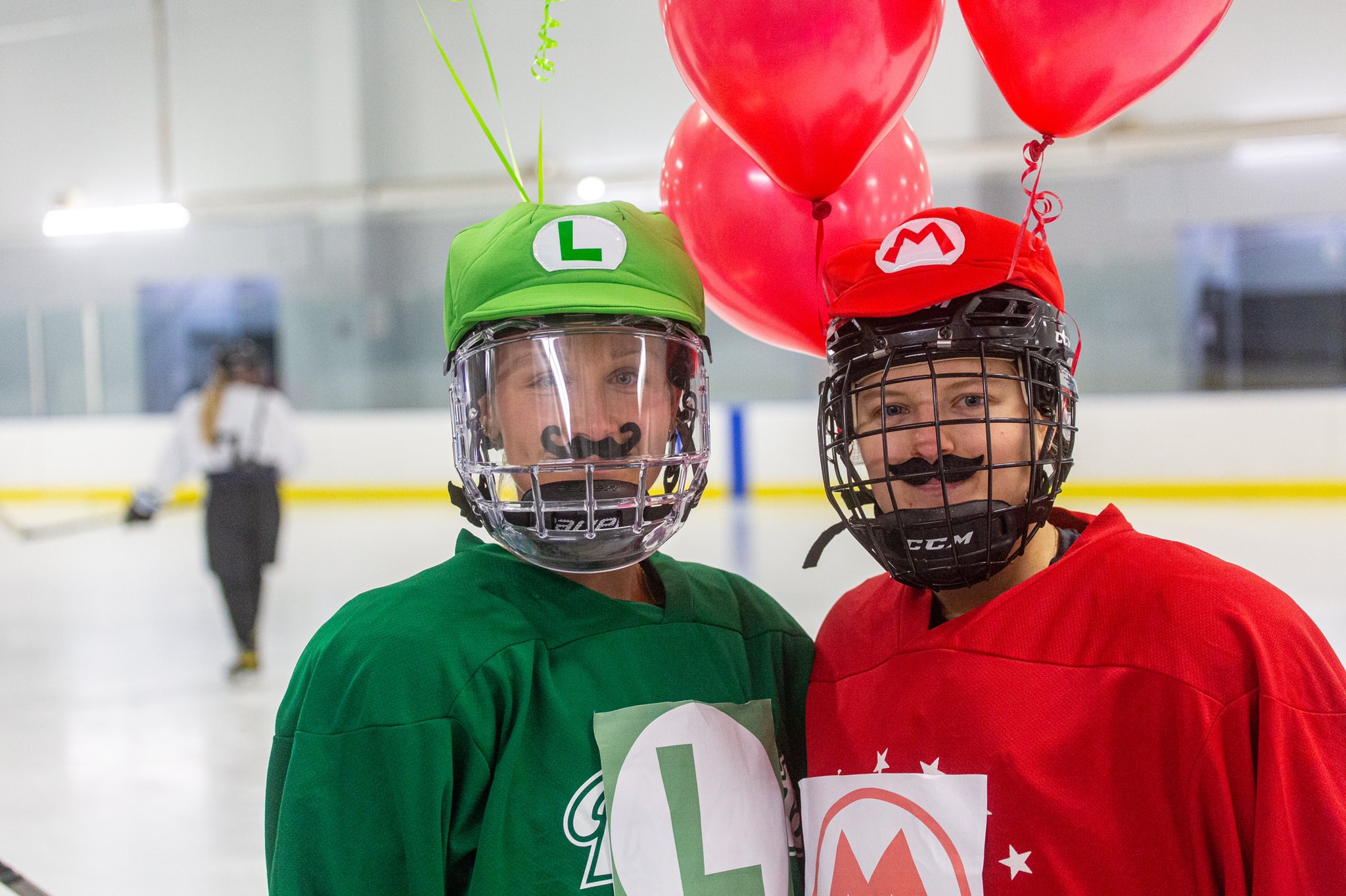 Two Buffalo Beauts players dressed up as Luigi and Mario, complete with hats, balloons and fake mustaches