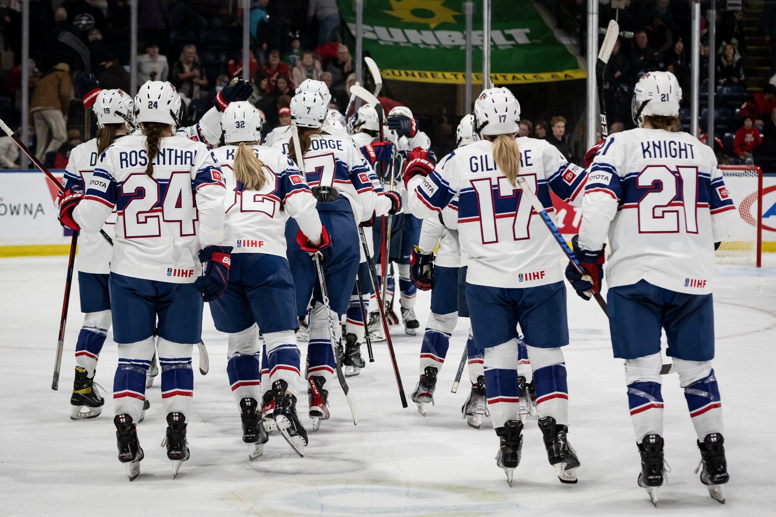 Members of the USA Hockey team gather on the ice in red, white and blue uniforms after a Rivalry Series victory.