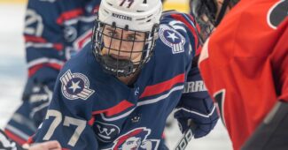 Photo of Riveters forward Kennedy Ganser in red, white and blue uniform with Riveters logo.