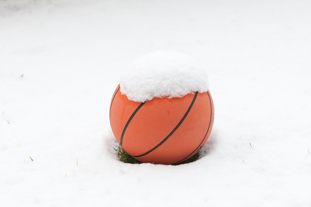 Photo of a basketball sitting in the snow.
