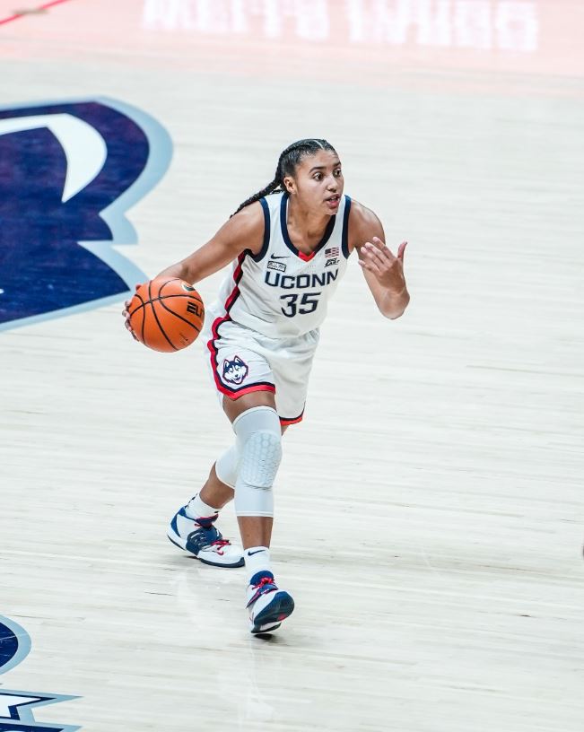UConn sophomore Azzi Fudd brings the ball up the court in UConn red, white and blue home uniform.