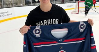 Goalie Katie Burt poses with a Metropolitan Riveters jersey after being signed to the team. (Photo Credit / Metropolitan Riveters Twitter Page)