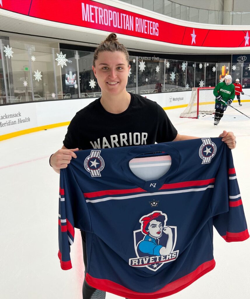 Goalie Katie Burt poses with a Metropolitan Riveters jersey after being signed to the team. (Photo Credit / Metropolitan Riveters Twitter Page)