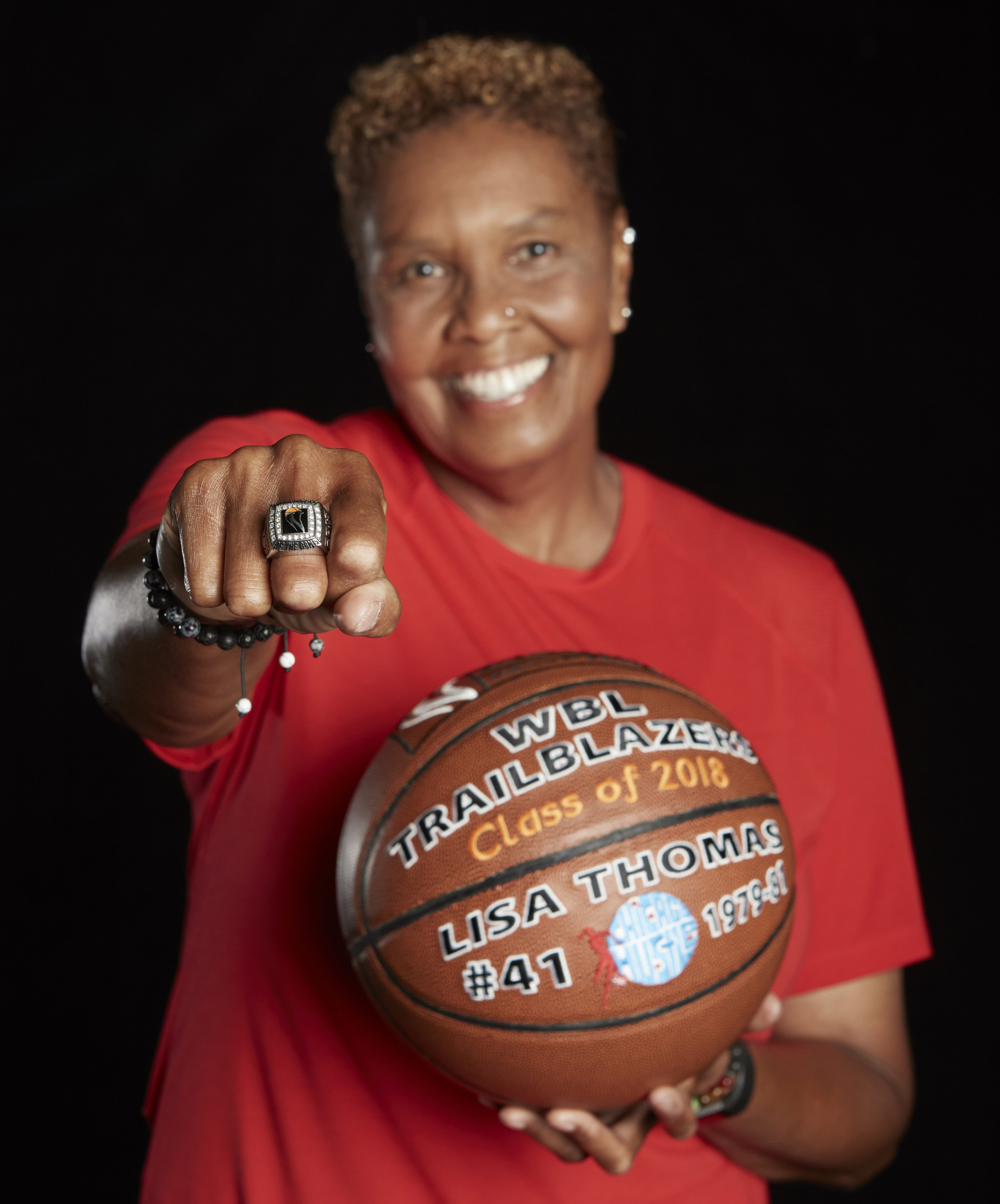 Lisa Thomas poses with ring and commemorative ball honoring her 2018 Women's Basketball Hall of Fame induction.