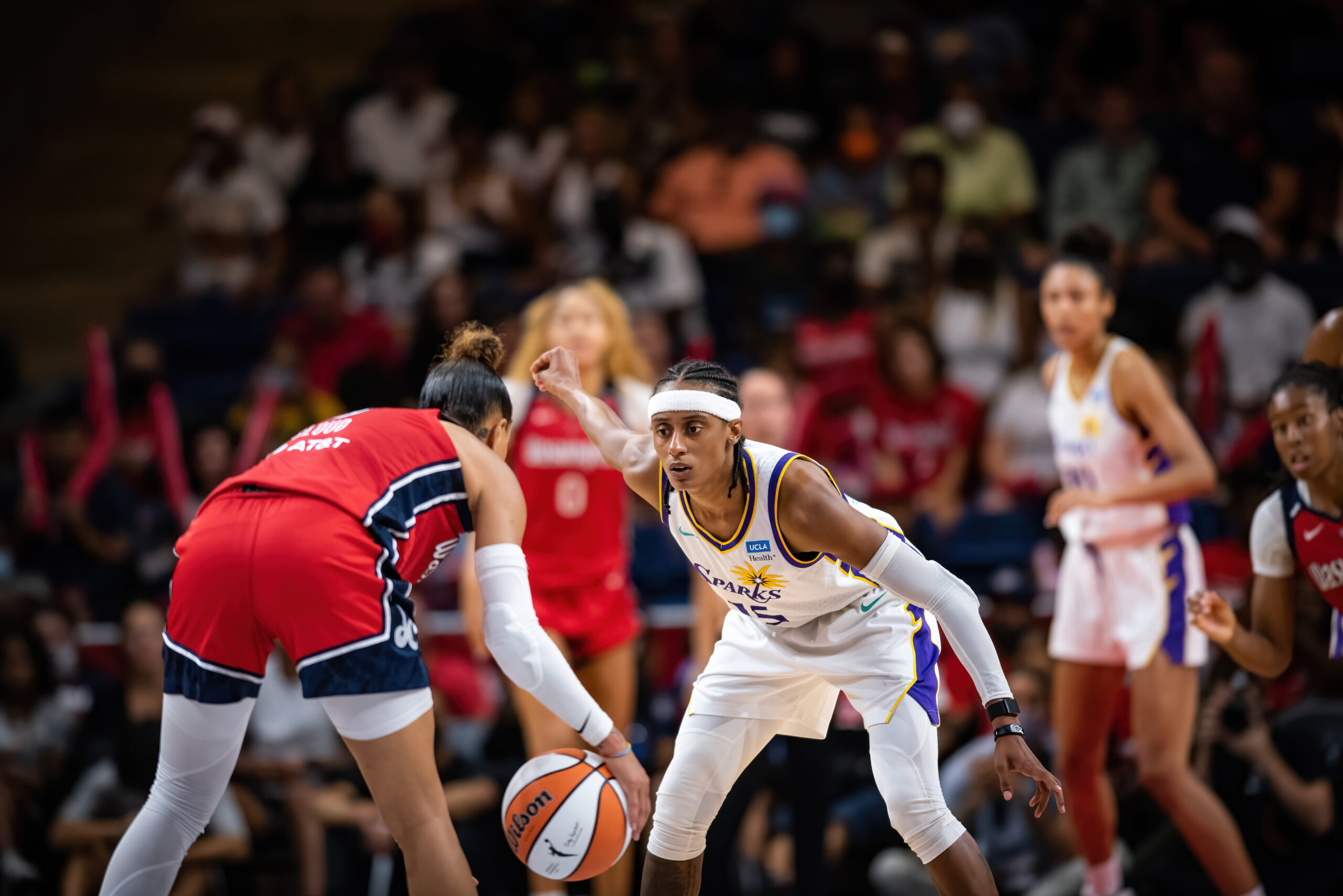 Los Angeles Sparks guard Brittney Sykes sits in a defensive stance against Washington Mystics point guard Natasha Cloud.