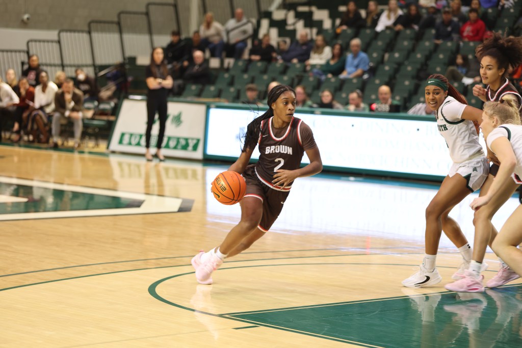 Brown guard Kyla Jones dribbles the ball with her right hand near the top of the key, looking to get to the basket.