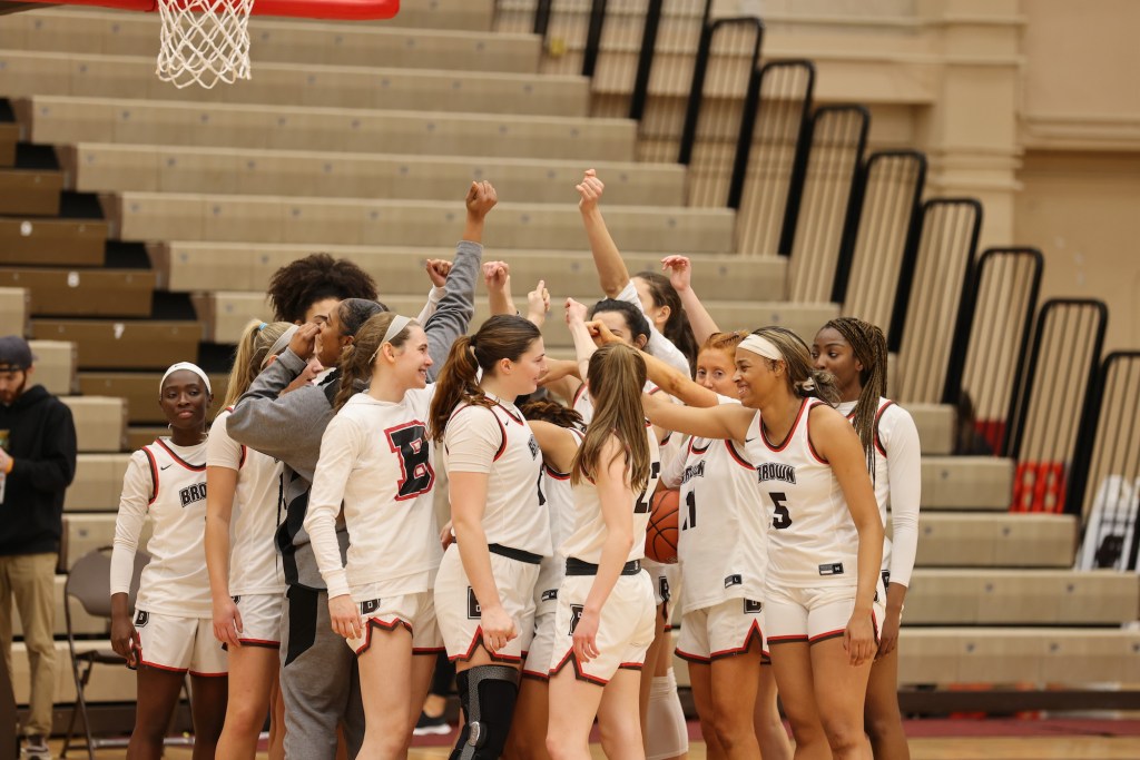 The Brown Bears huddle as a team, with each player raising one arm toward the center.