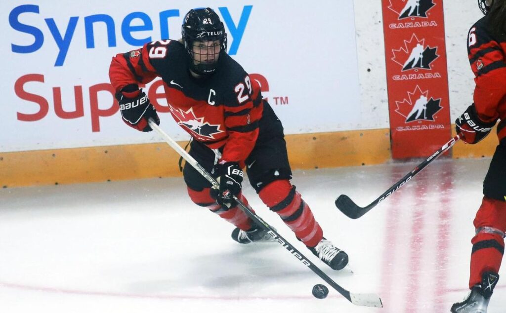 Marie-Philip Poulin skating in red and black Team Canada uniform.