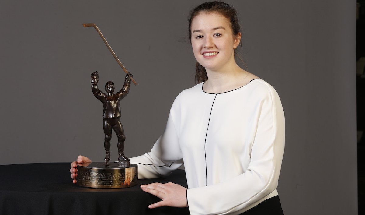 Daryl Watts seated with the Patty Kazmaier Memorial Award.