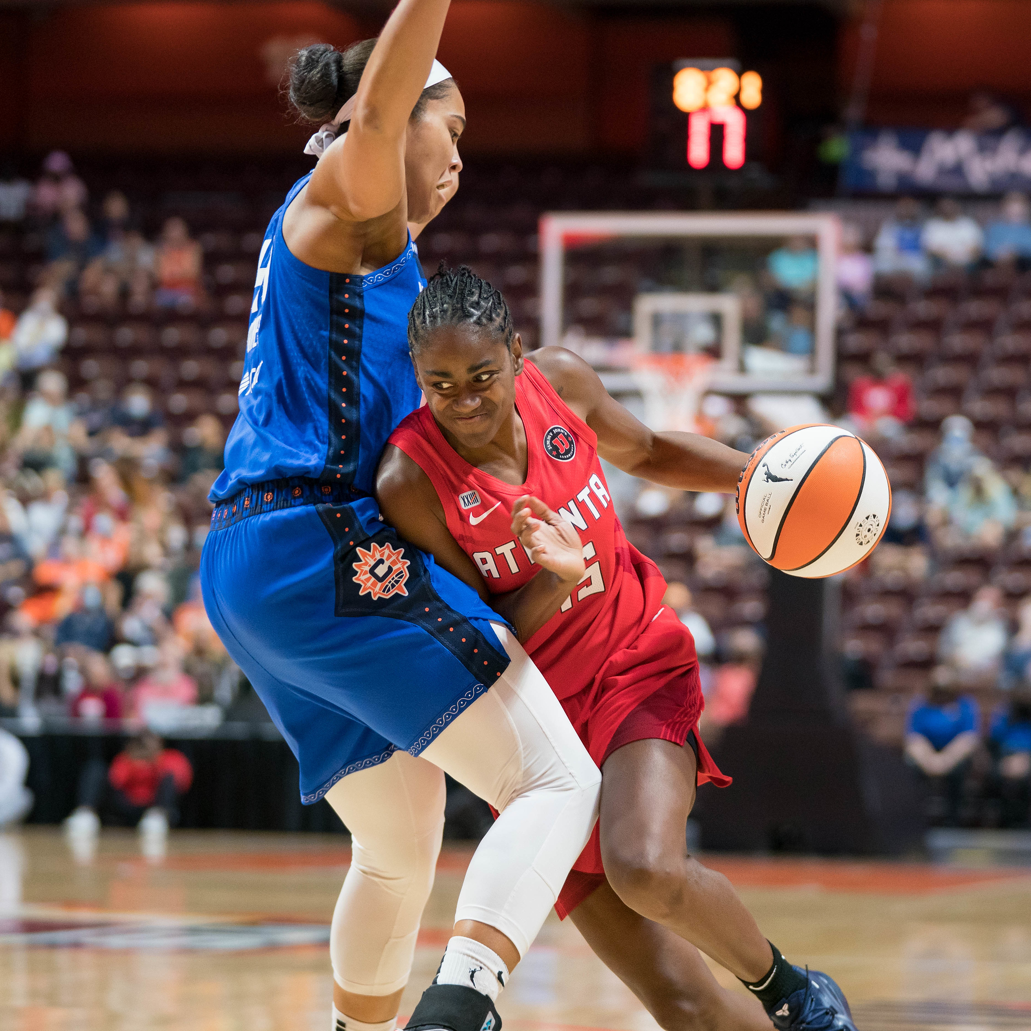 Atlanta Dream guard Tiffany Hayes drives to the basket with her left hand, trying to get around Connecticut Sun forward Brionna Jones.