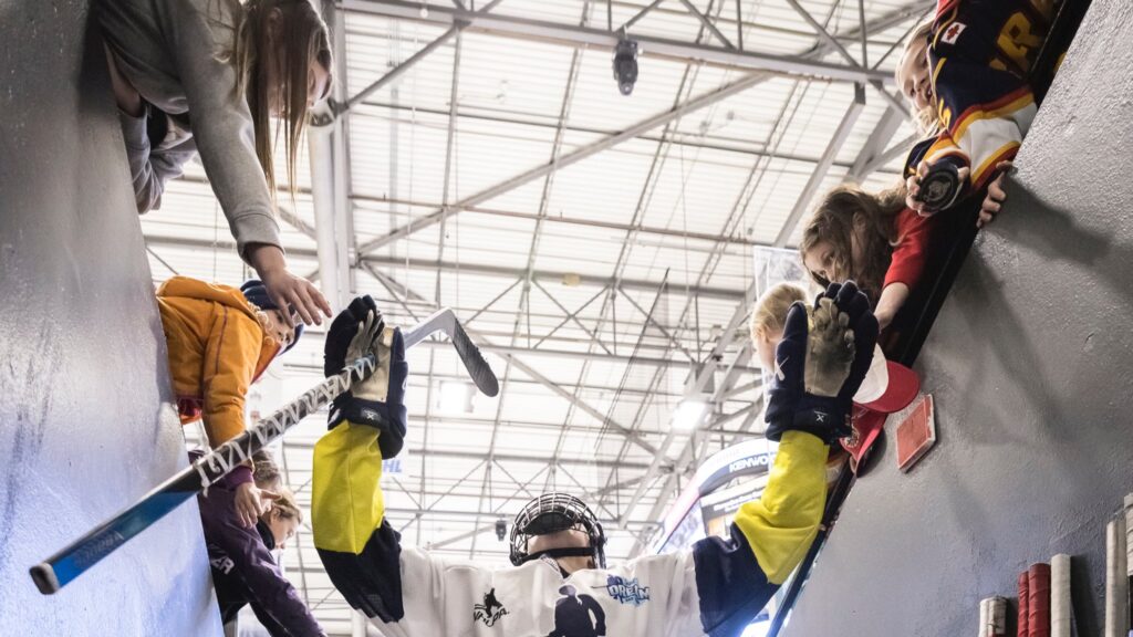 Heather Pollock gives high-fives to fans while exiting the ice in a recent PWHPA matchup. (Photo Credit / PWHPA Twitter Page)