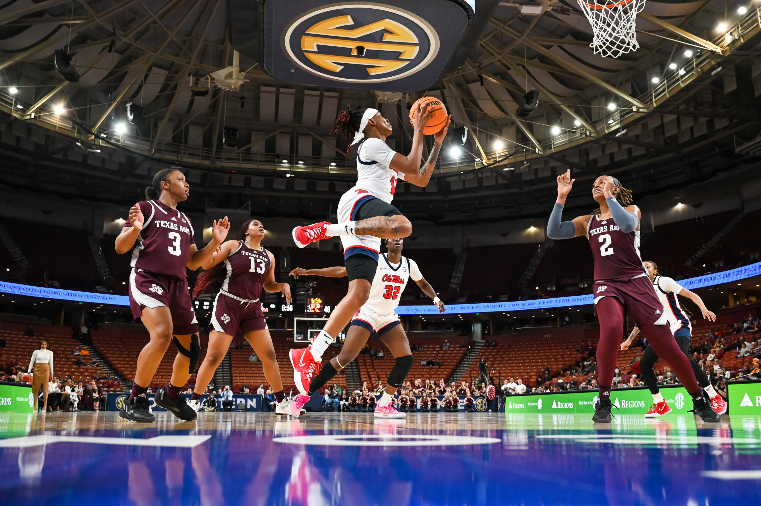 Mississippi's Angel Baker is shown in midair near the basket, clutching the ball with both hands and with her right leg bent to the side.