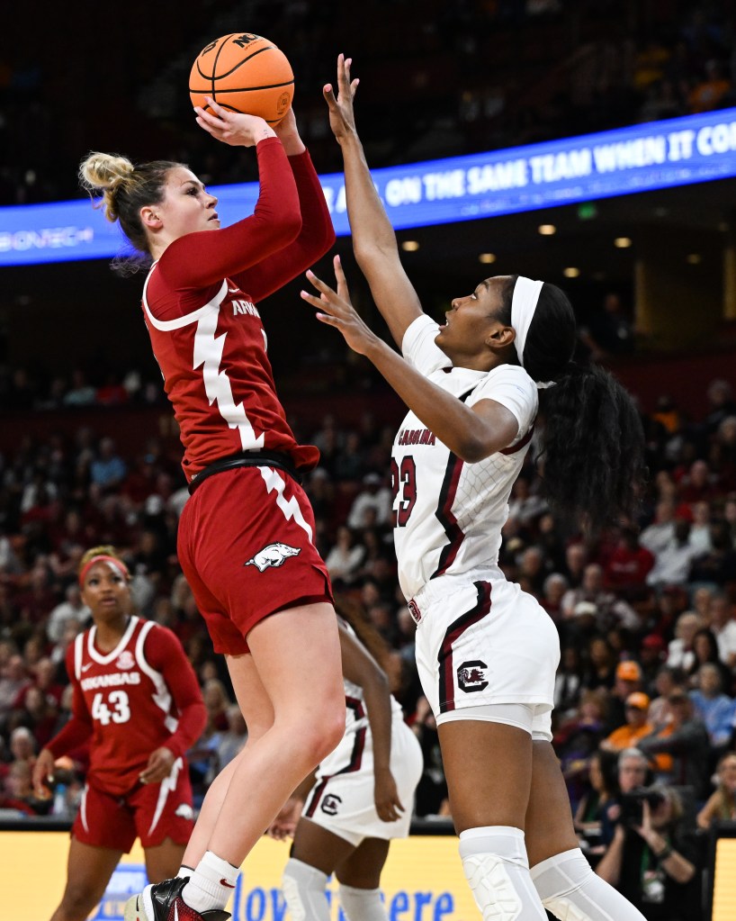 An Arkansas player rises to shoot as a South Carolina player closely contests.