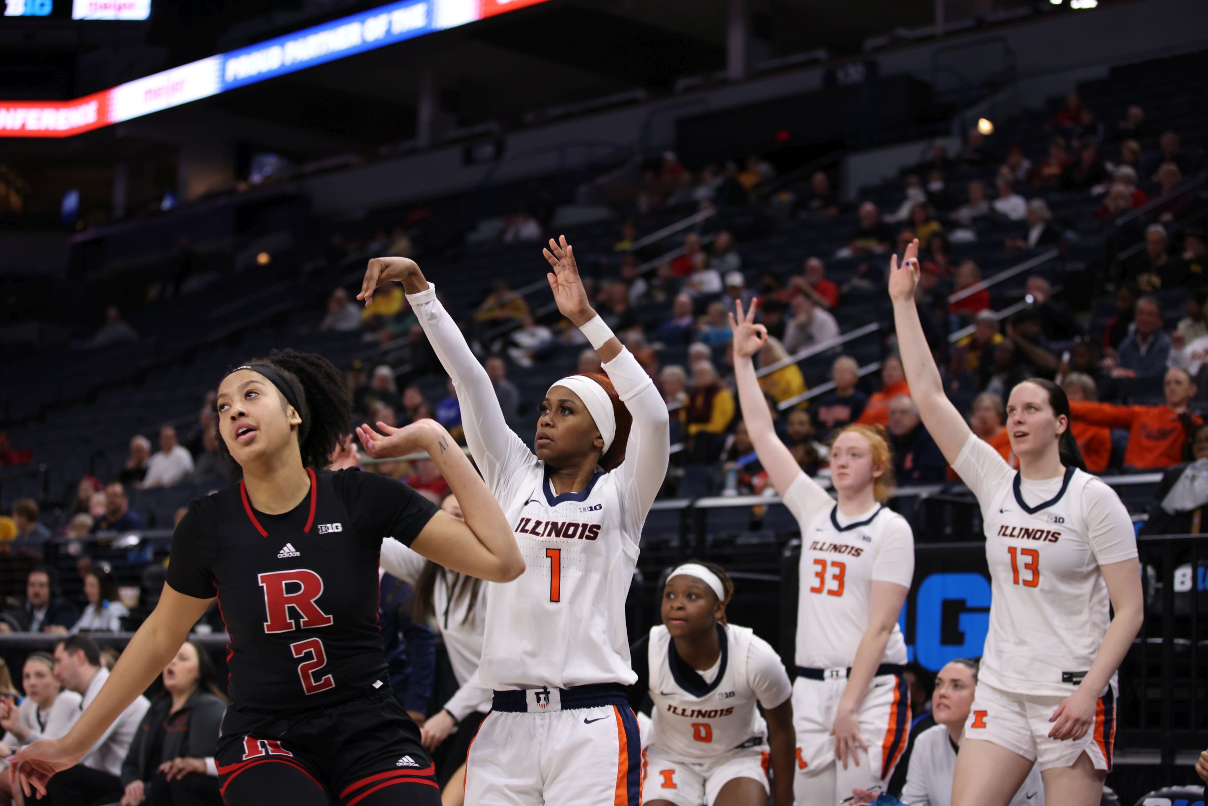 Illinois junior guard Genesis Bryant shoots a 3-pointer and holds her follow-through as the bench starts to celebrate behind her.