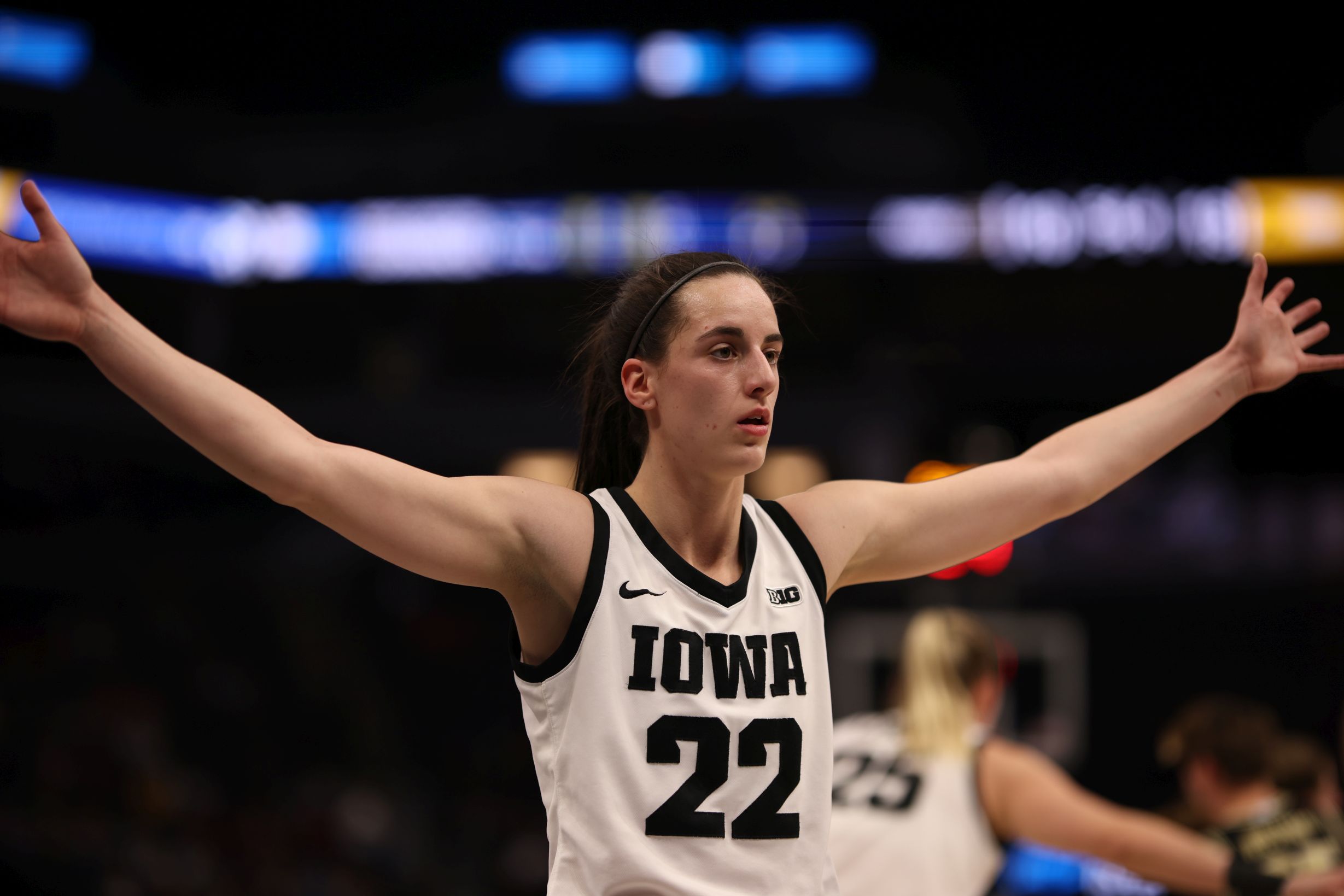 Iowa guard Caitlin Clark extends her arms, her hands at head level.