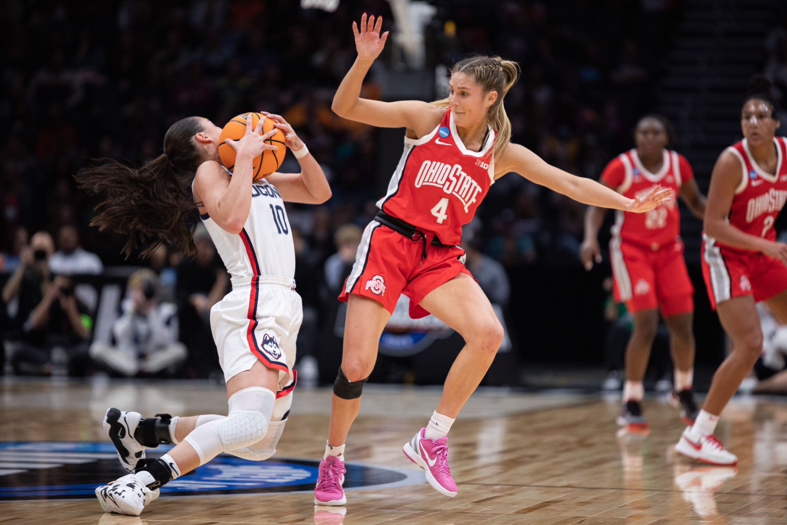 Ohio State's Jacy Sheldon defends UConn's Nika Muhl as Muhl falls to the floor.