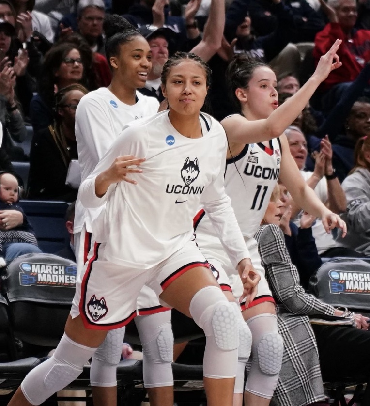 UConn players Aubrey Griffin (left), Amari Deberry (middle) and Lou Lopez Sénéchal (right) celebrate on the bench during UConn's first round NCAA Tournament matchup on Saturday, Mar. 18, 2023. (Photo Credit / UConn women's basketball Twitter)