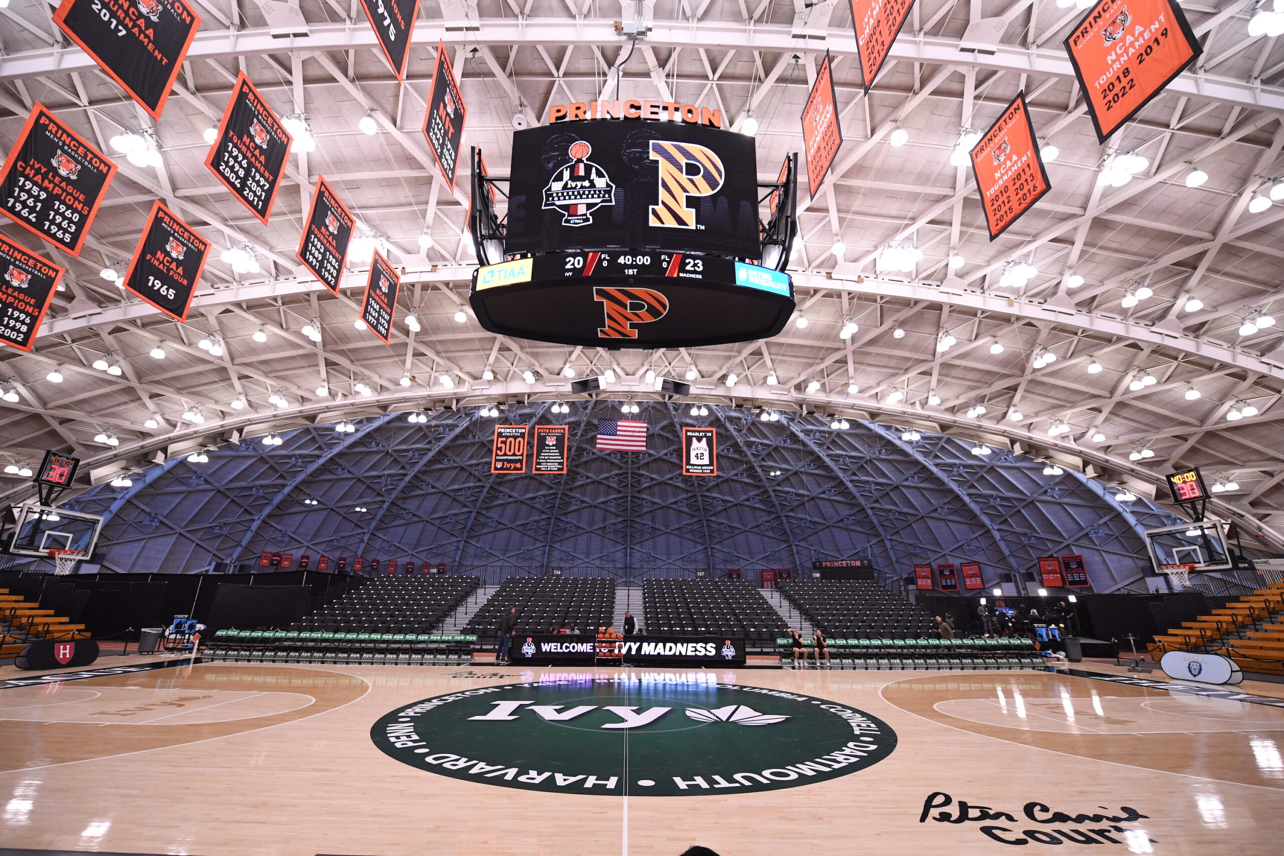An empty Jadwin Gymnasium court, with the Ivy League Tournament and Princeton logos on the video board and the score listed as 20-23.