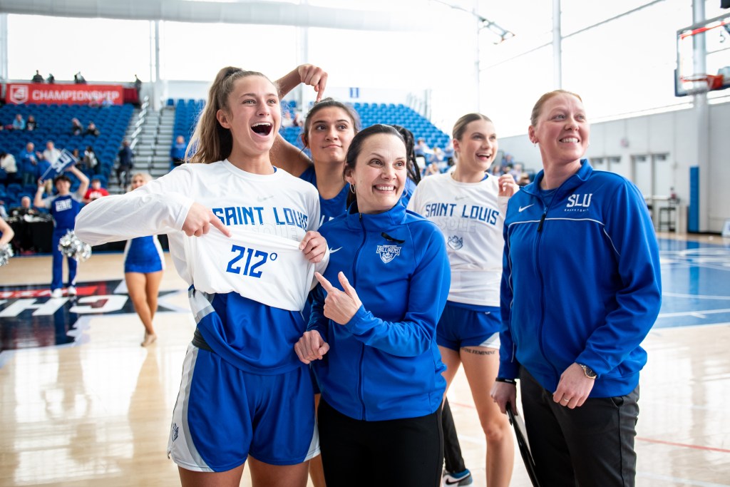 Saint Louis head coach Rebecca Tillett points to the 212° sewn inside the shirts of the team's warmup shirts