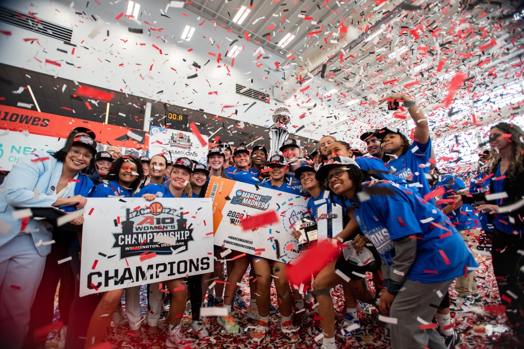 Confetti falls on Saint Louis as they hoist the trophy and hold up their NCAA Tournament ticket and A-10 champions sign.