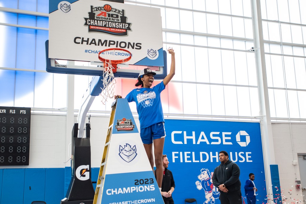 Brooke Flowers waves around her piece of the net while standing on a ladder 