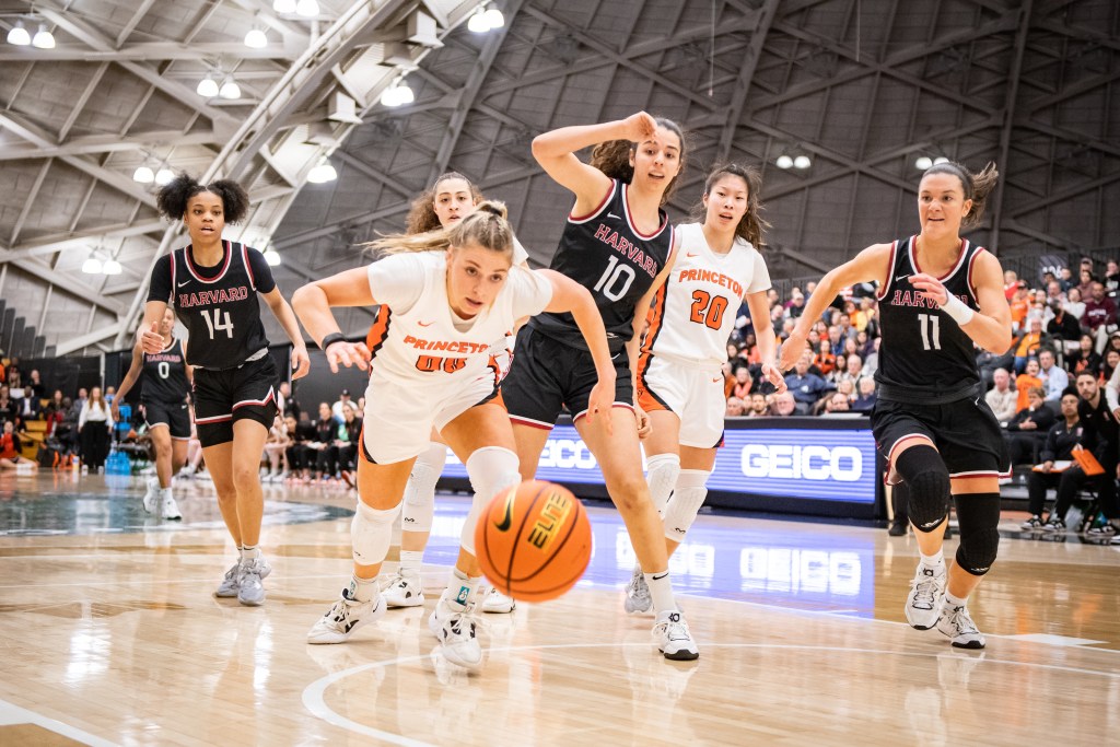 Princeton forward Ellie Mitchell dives for a ball that is rolling toward the camera as five other players trail her.