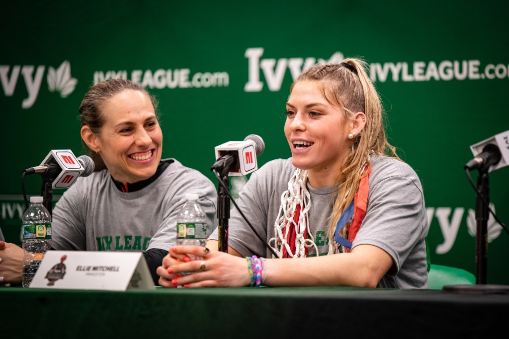 Princeton forward Ellie Mitchell gives a half-smile as she answers a reporter's question. Head coach Carla Berube looks at her with a wide smile.